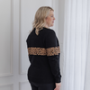 A mum modelling a black and leopard print sweater from the back.