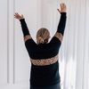 A size XL mum showing the back of a black and leopard print nursing jumper.