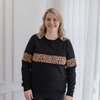 A mum modelling a black, breastfeeding friendly jumper that features leopard print.