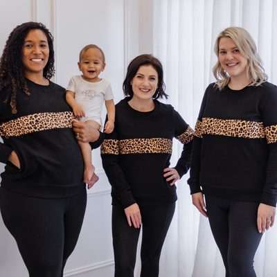 Three different sized mothers modeling the same black and leopard print breastfeeding jumper.