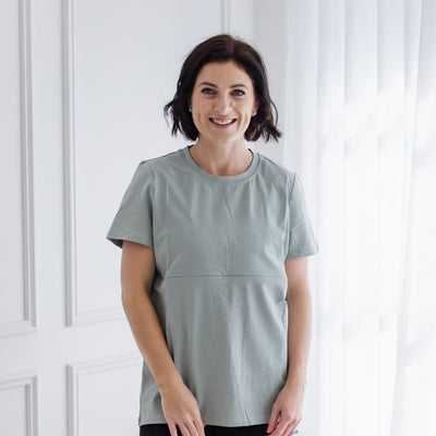 A size S mum models a plain green t-shirt with a horizontal breastfeeding zip.