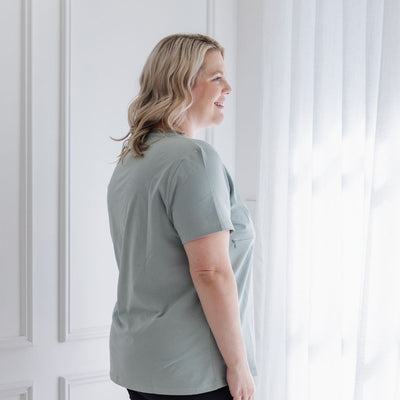 A young mum models the black of a pale green nursing top.