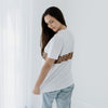 A young woman shows the fit of a white nursing t-shirt from behind.