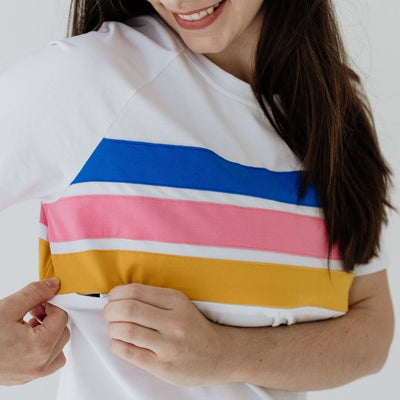 A close up of three coloured stripes on a white t-shirt with a hidden nursing zip.