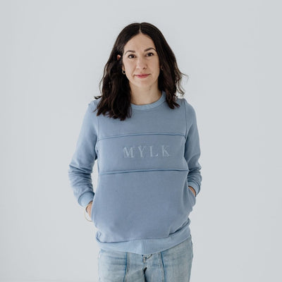 A size S mum wearing a steel blue nursing sweater with pockets.