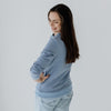 A size XS mum modelling a steel blue breastfeeding jumper from the back.
