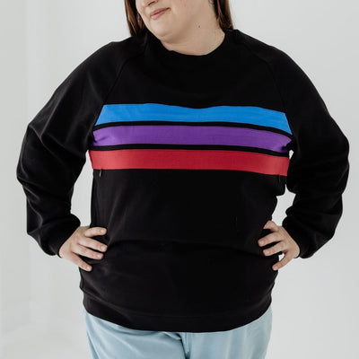 A black nursing jumper that features three coloured stripes, blue, purple and red, that hide an invisible zip.